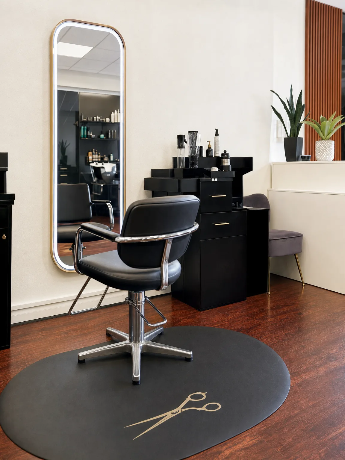 Melany's station — gold lit mirror and black chair
